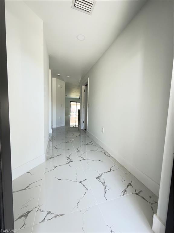 Unfurnished room featuring baseboards and light marble finish flooring