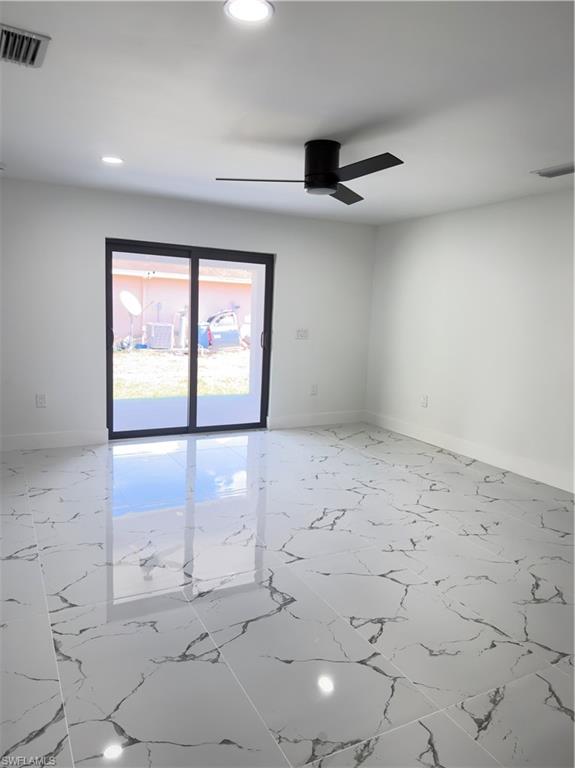 Empty room featuring light marble finish floors, recessed lighting, and a ceiling fan