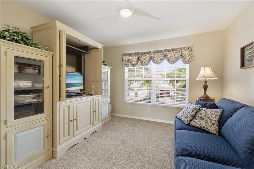 Living area with a ceiling fan and light carpet