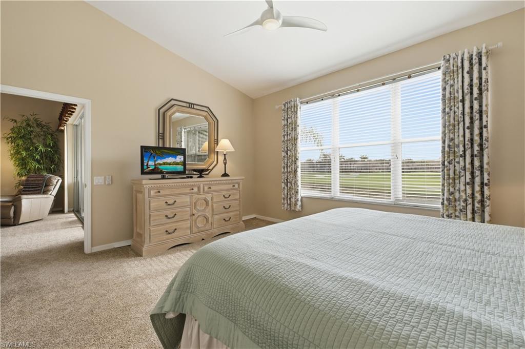 Bedroom with lofted ceiling, light colored carpet, and ceiling fan