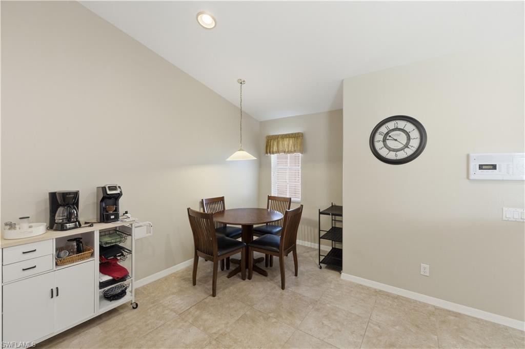 Dining space featuring baseboards and vaulted ceiling