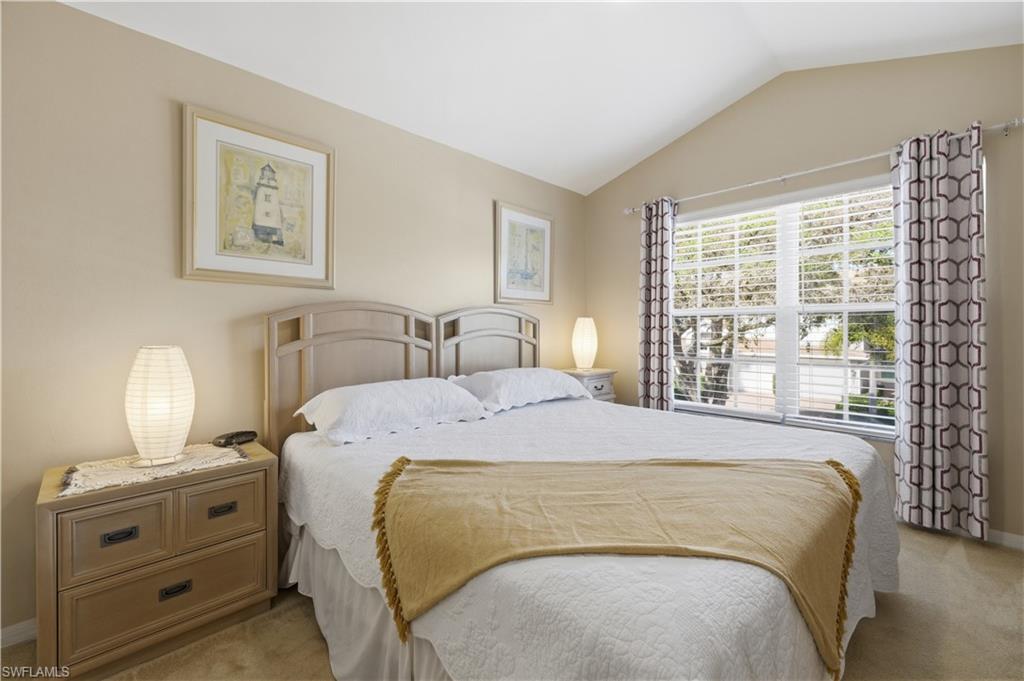 Bedroom featuring carpet flooring and vaulted ceiling