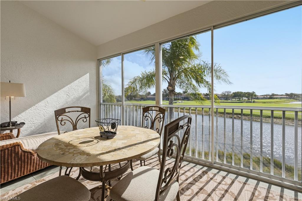 Sunroom / solarium with a water view, vaulted ceiling, and view of golf course