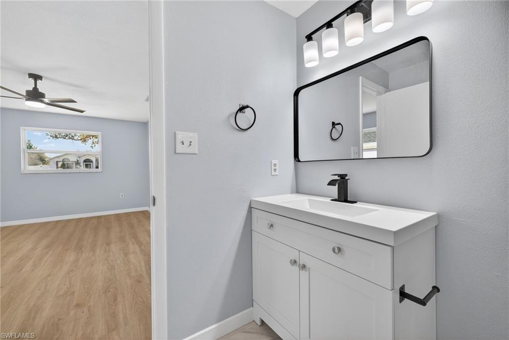 Bathroom featuring vanity, a ceiling fan, and light wood-type flooring