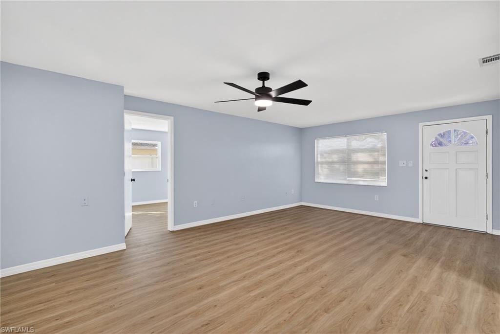 Unfurnished living room with a ceiling fan and wood finished floors