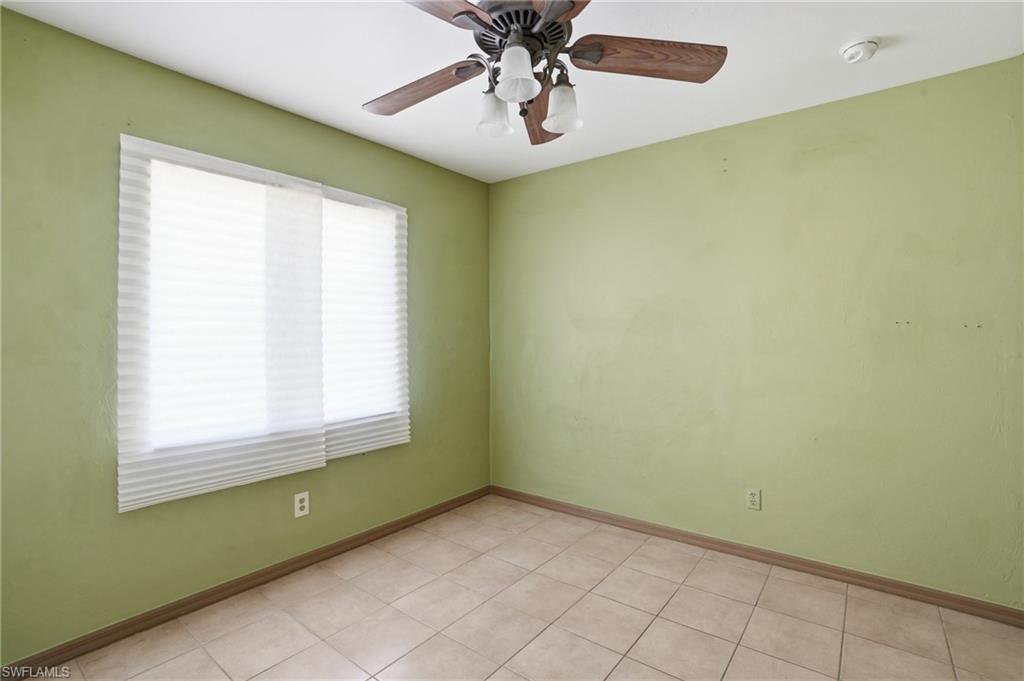 Unfurnished room with a ceiling fan and light tile patterned flooring