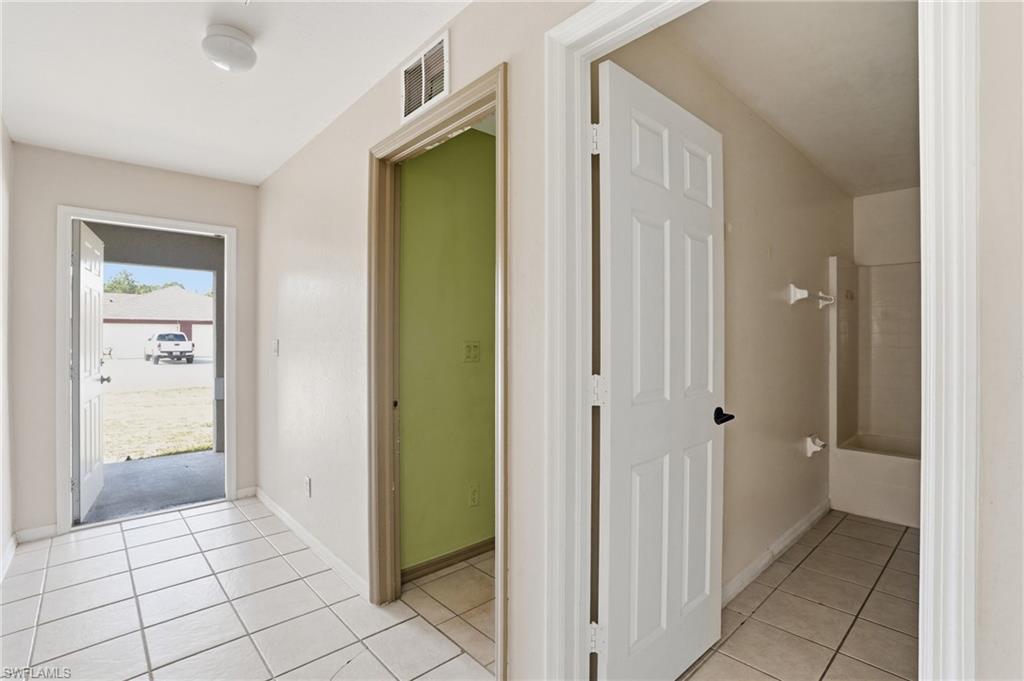 Hallway with light tile patterned floors and baseboards