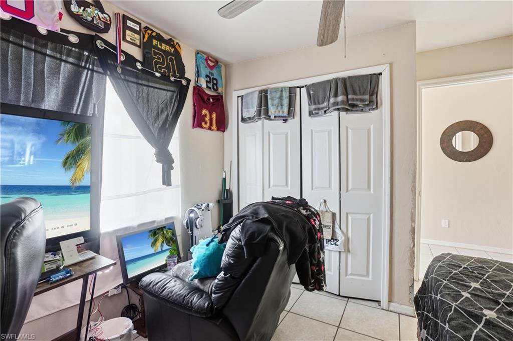 Bedroom featuring a closet, a ceiling fan, and light tile patterned floors