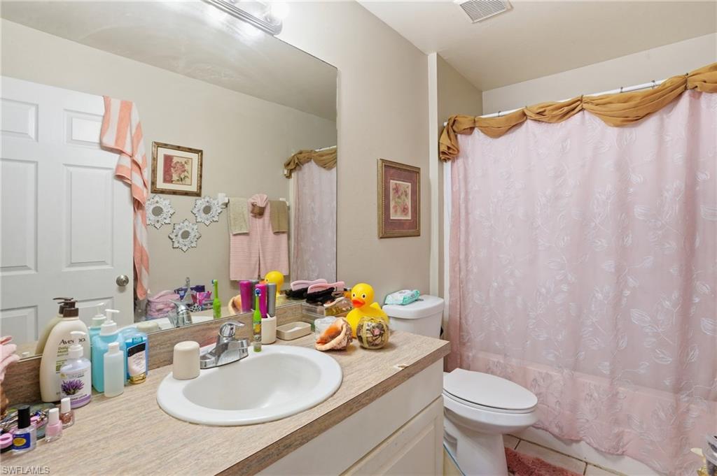 Bathroom with vanity and shower / bathtub combination with curtain