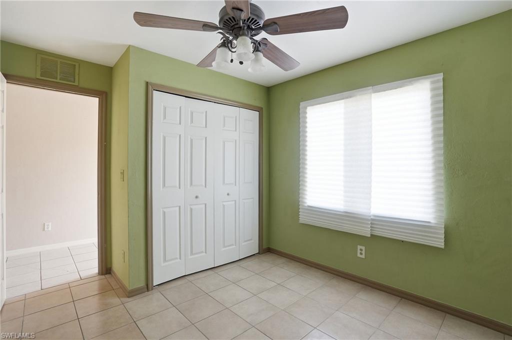 Unfurnished bedroom featuring ceiling fan, a closet, and light tile patterned floors