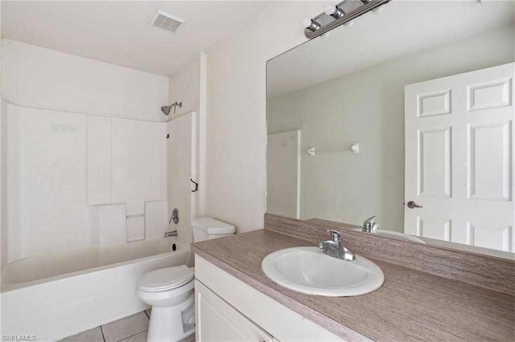 Full bath featuring vanity, shower / tub combination, and light tile patterned floors