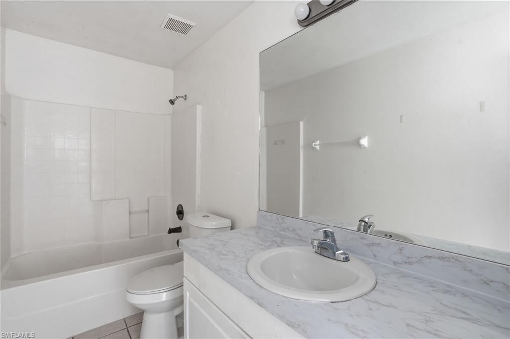 Full bath featuring vanity, bathing tub / shower combination, and light tile patterned floors