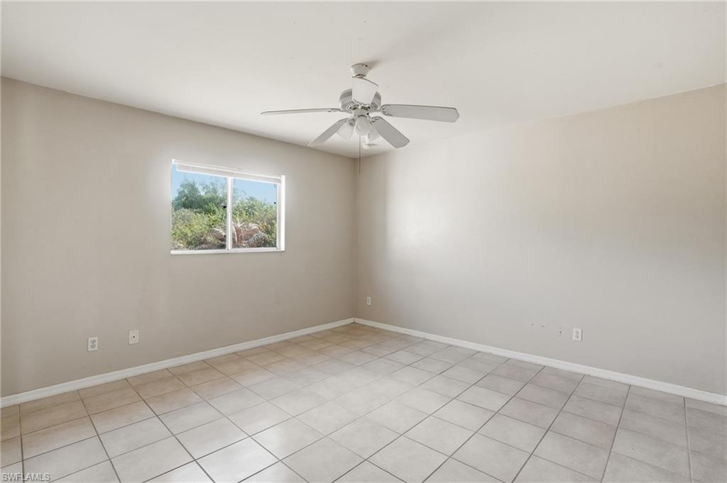 Spare room featuring ceiling fan and baseboards