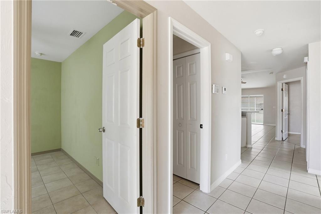 Hallway with light tile patterned flooring and baseboards