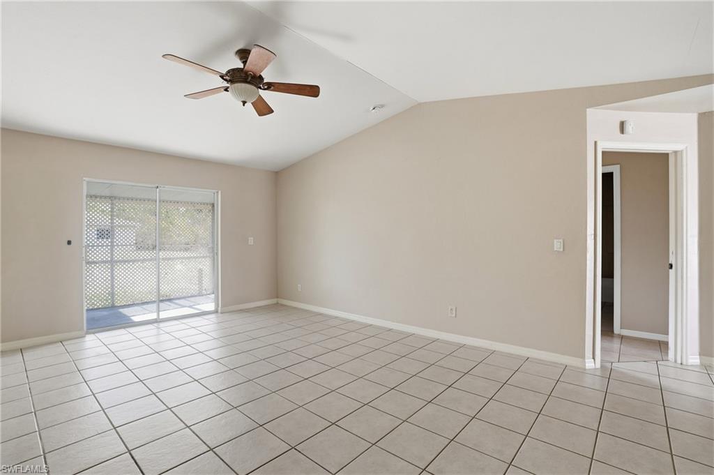 Unfurnished room featuring ceiling fan, lofted ceiling, and light tile patterned floors