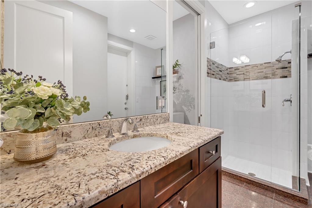 Full bath featuring a shower stall, vanity, recessed lighting, and granite floors