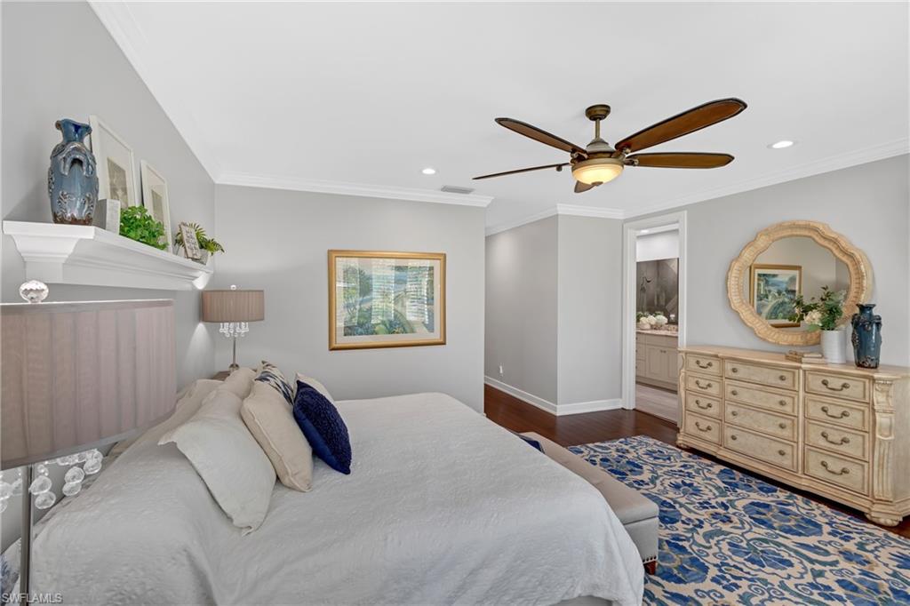 Bedroom with ceiling fan, dark wood-style flooring, ornamental molding, connected bathroom, and recessed lighting