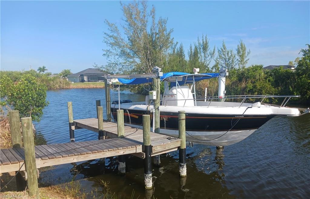 Private boat dock featuring wood decking and a covered boat lift
