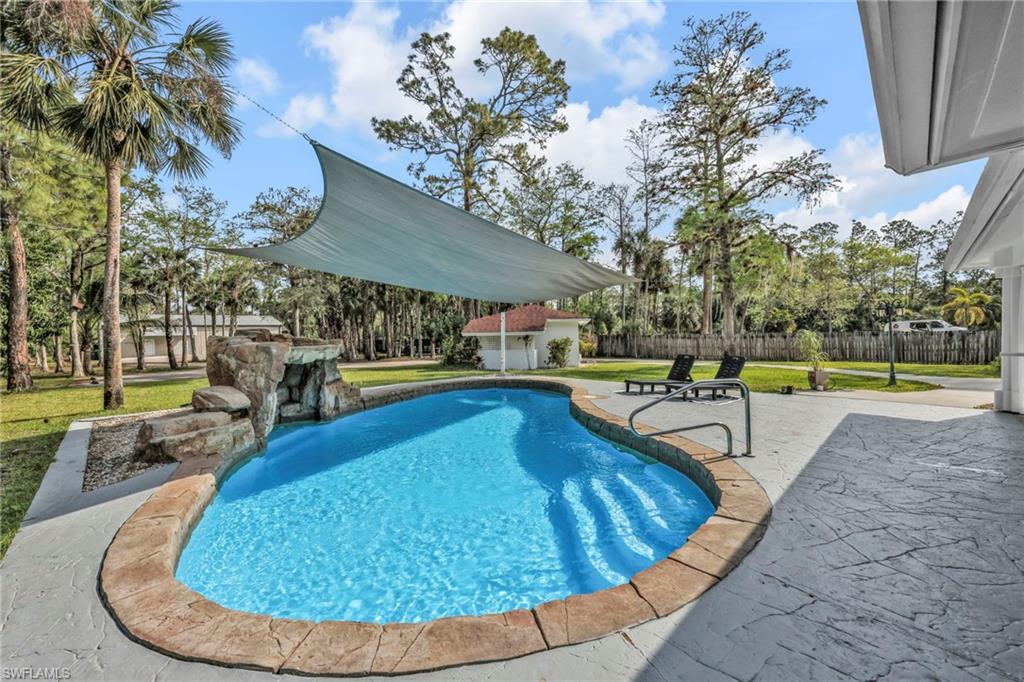 View of pool with patio surround and an outbuilding