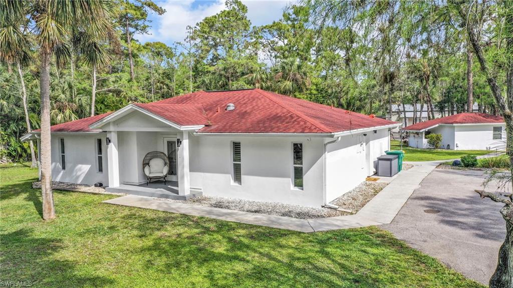 Mediterranean / spanish house with a front lawn, stucco siding, covered porch, and a shingled roof