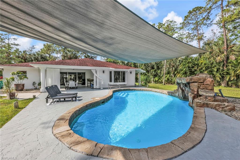 Outdoor pool featuring a patio and a yard