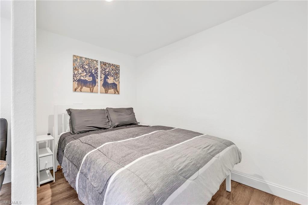 Bedroom with wood finished floors and baseboards