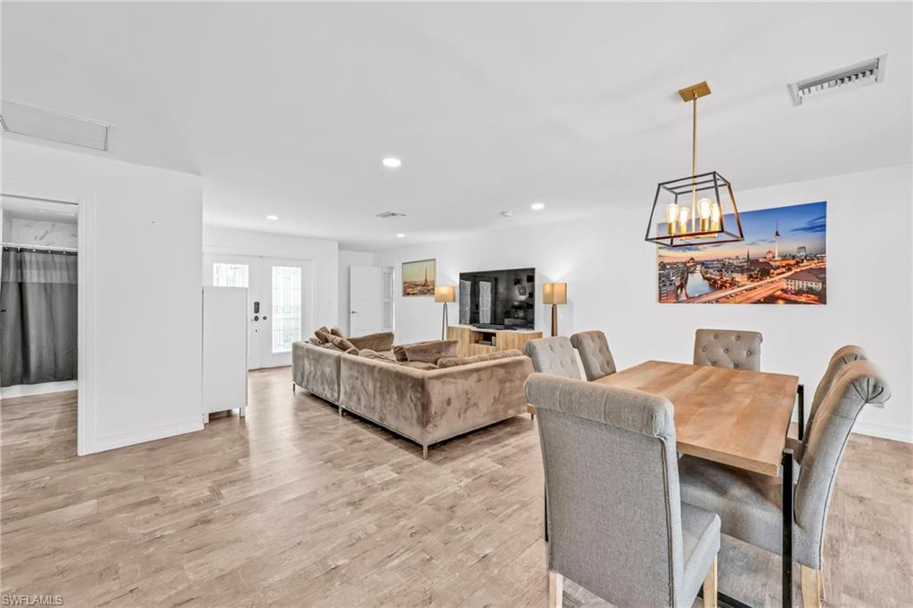 Dining space with light wood finished floors and a chandelier