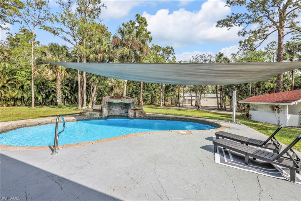 Swimming pool with a yard and a patio area