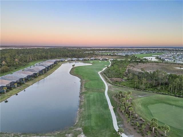 Aerial view at dusk featuring a water view