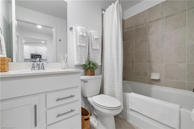 Full bathroom with shower / bathtub combination with curtain, vanity, and toilet