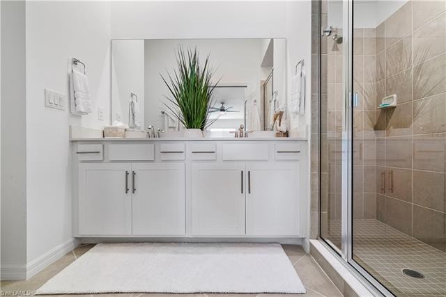 Bathroom featuring tile patterned floors, vanity, and a shower with door