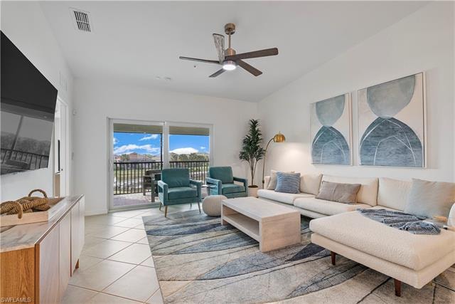 Tiled living room featuring vaulted ceiling and ceiling fan