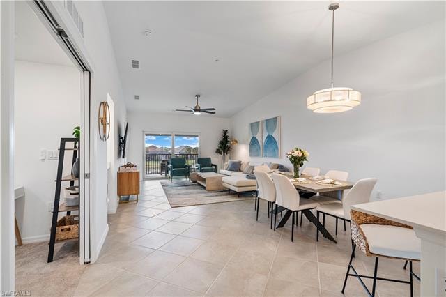 Tiled dining space with high vaulted ceiling and ceiling fan