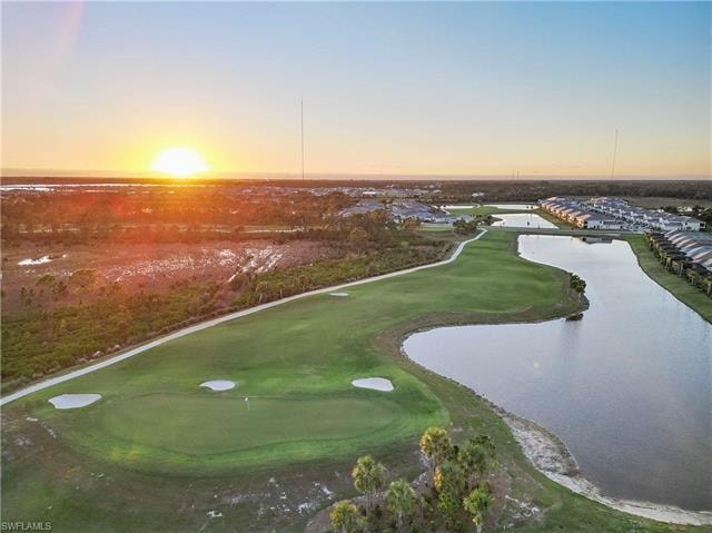 Aerial view at dusk featuring a water view
