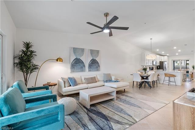 Tiled living room featuring ceiling fan and vaulted ceiling