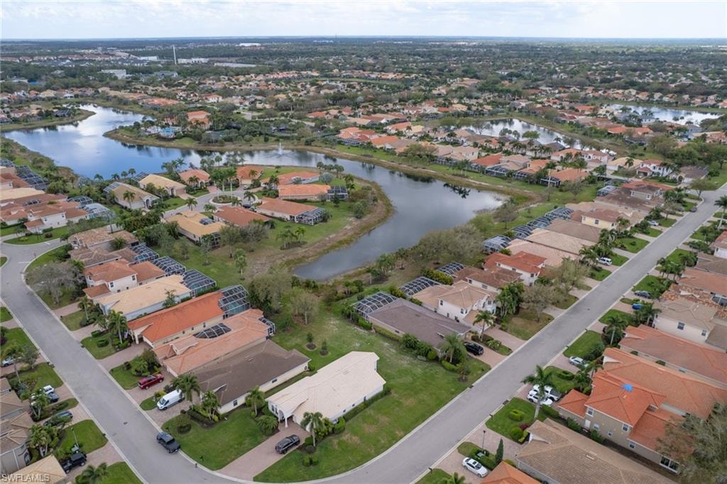 Aerial view of property and surrounding area featuring a large body of water and nearby suburban area