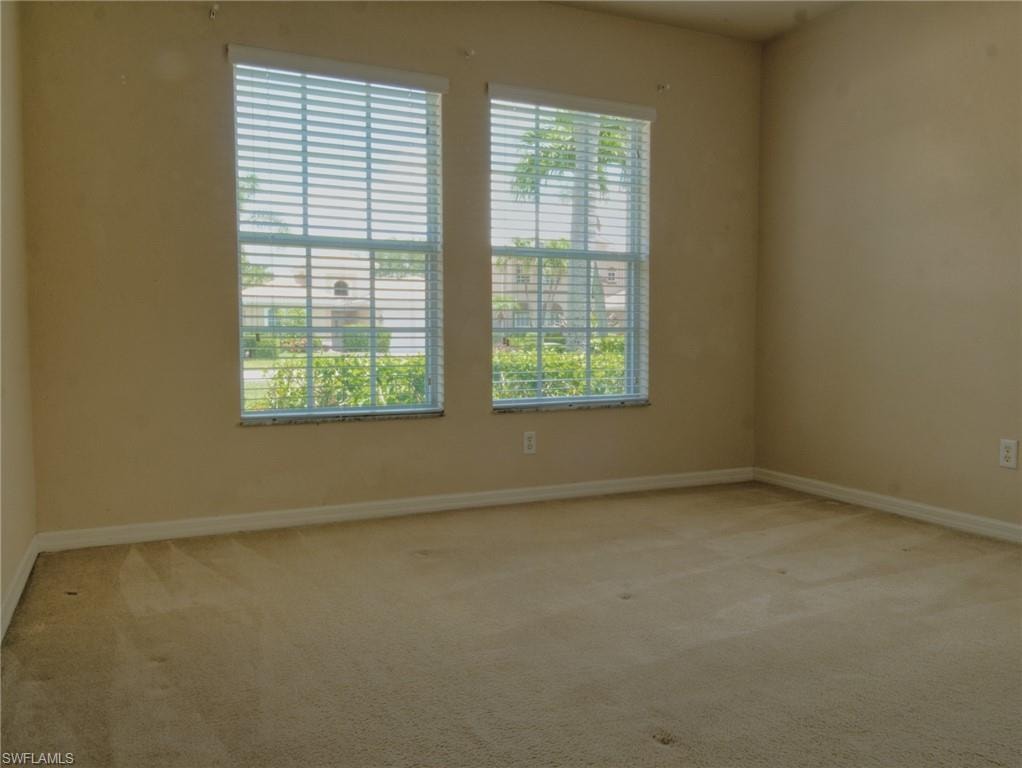 Two large windows with horizontal blinds and stone sills