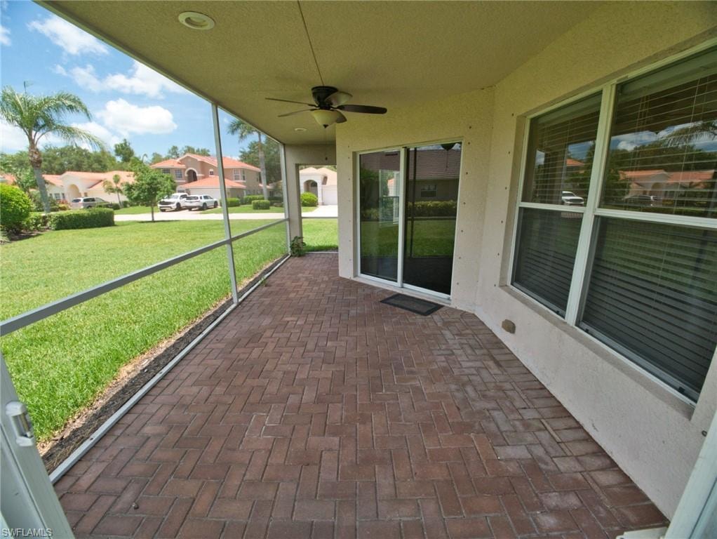 Screened patio featuring a ceiling fan, recessed lighting, and herringbone-patterned brick pavers