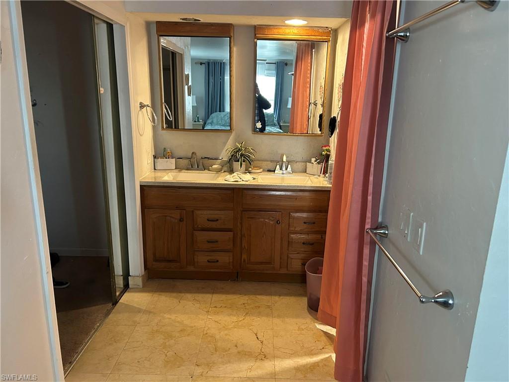 Full bathroom with double vanity and a shower stall
