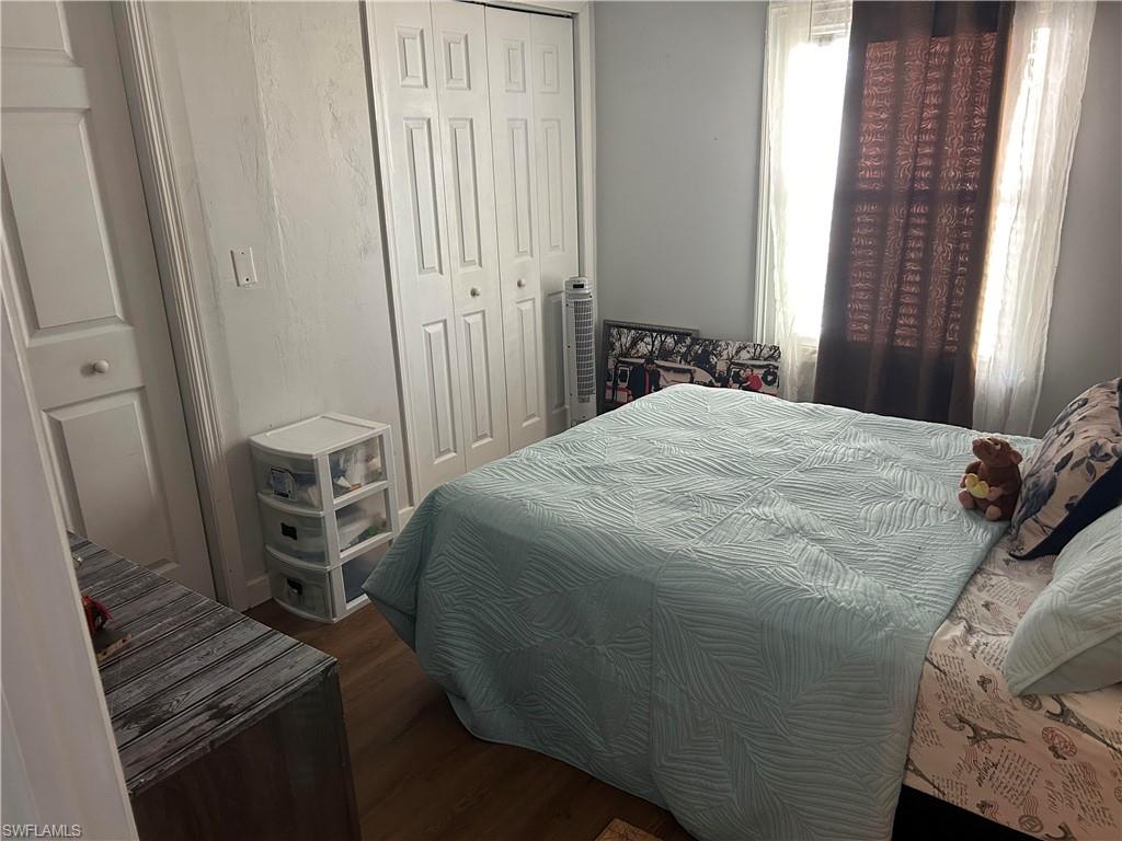 Bedroom featuring dark wood-type flooring and a closet