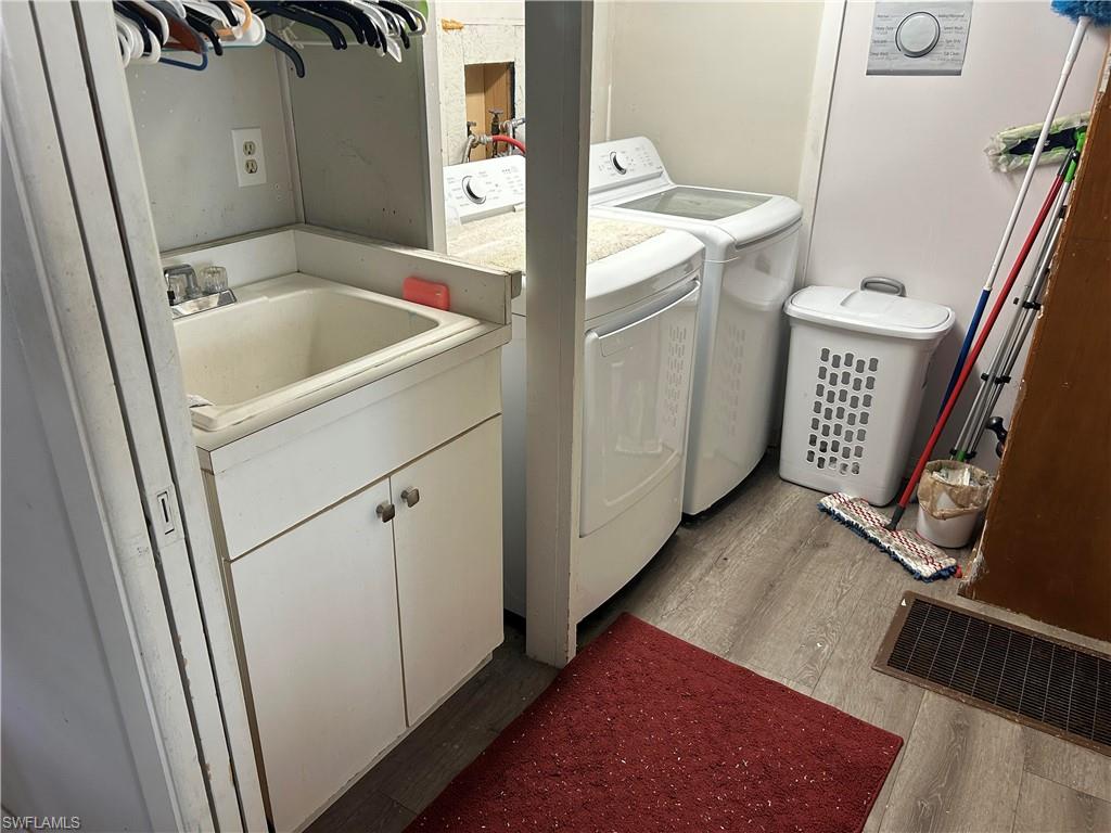 Laundry area featuring light wood-type flooring and independent washer and dryer