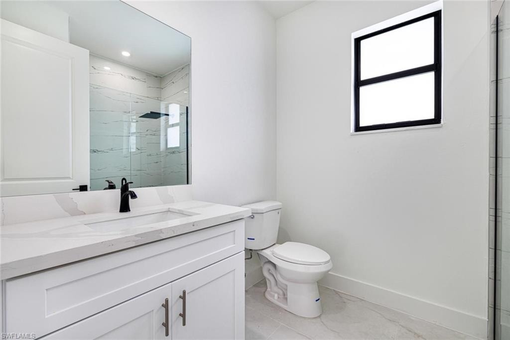 Dual vanity with integrated sinks, white cabinetry, and stone countertops