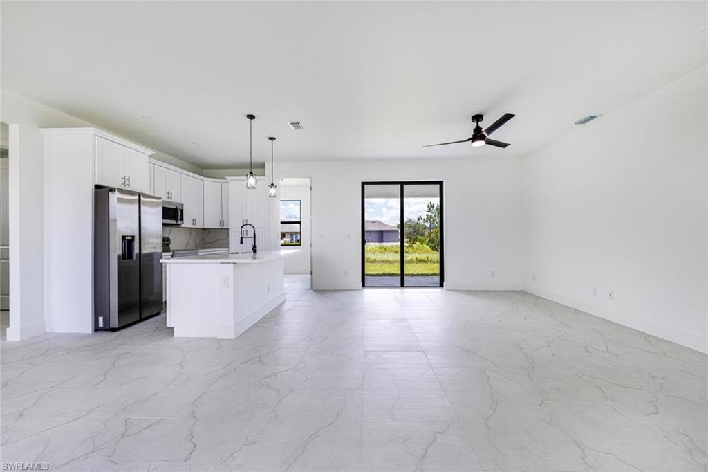Light-filled bedroom featuring white walls, large white sliding closet doors, a black ceiling fan, and white tile flooring