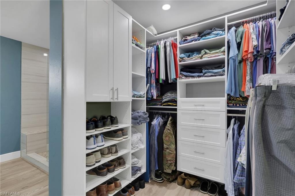Walk in closet with light wood-style flooring