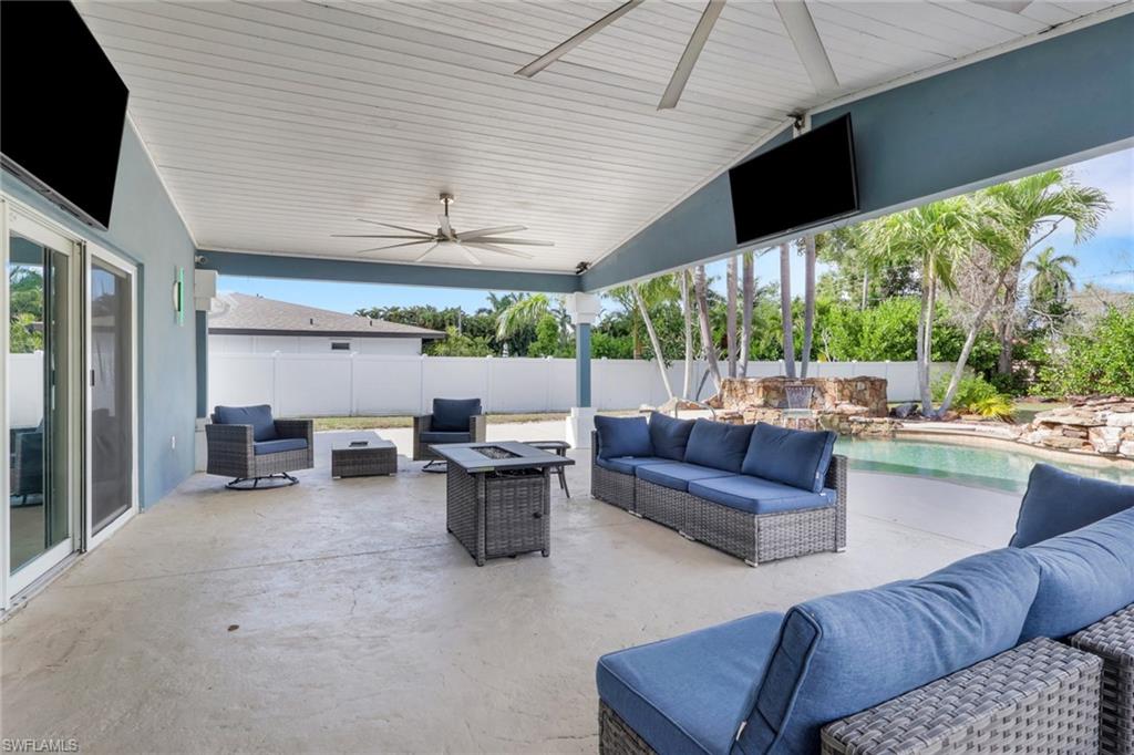 Fenced backyard with an outdoor living space with a fire pit, a patio, and a ceiling fan