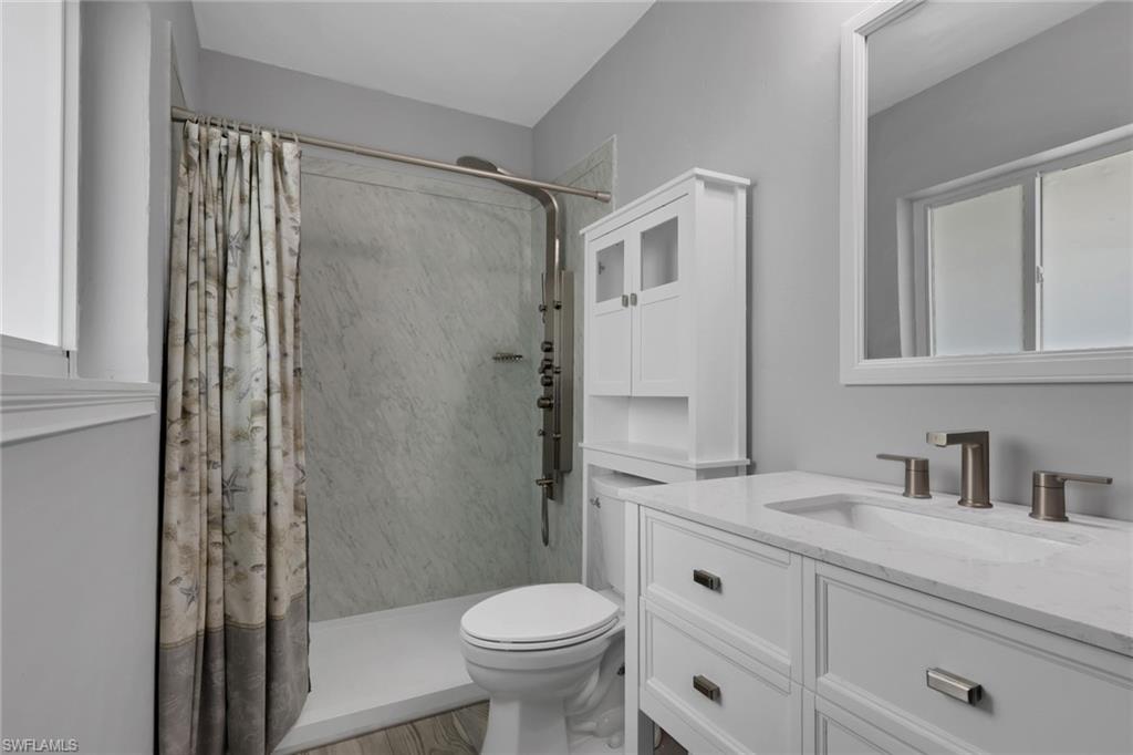Full bathroom with vanity and a shower stall