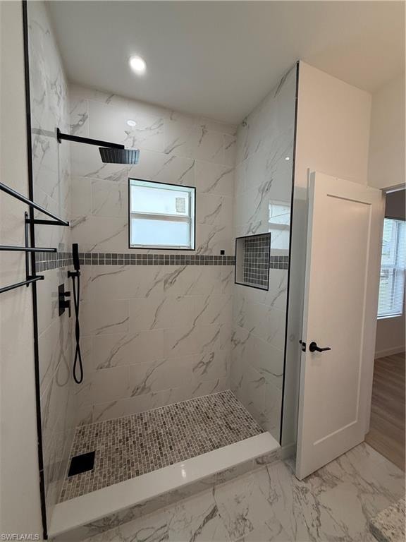 Bathroom featuring a marble finish shower, light marble finish floors, and recessed lighting