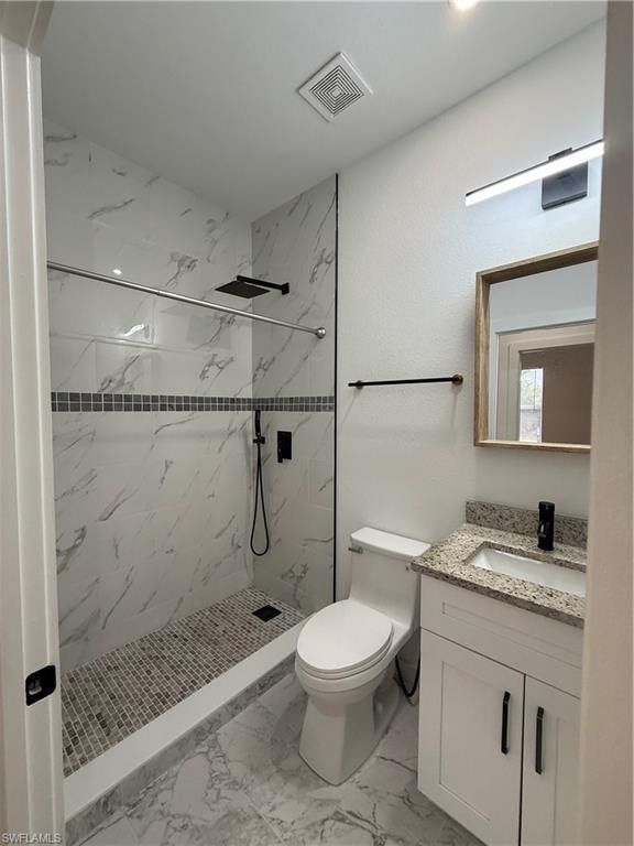Full bathroom with vanity, a marble finish shower, and light marble finish flooring