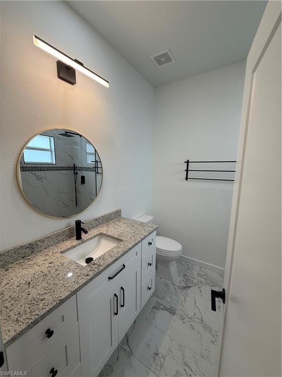 Bathroom featuring vanity, light marble finish flooring, and a marble finish shower