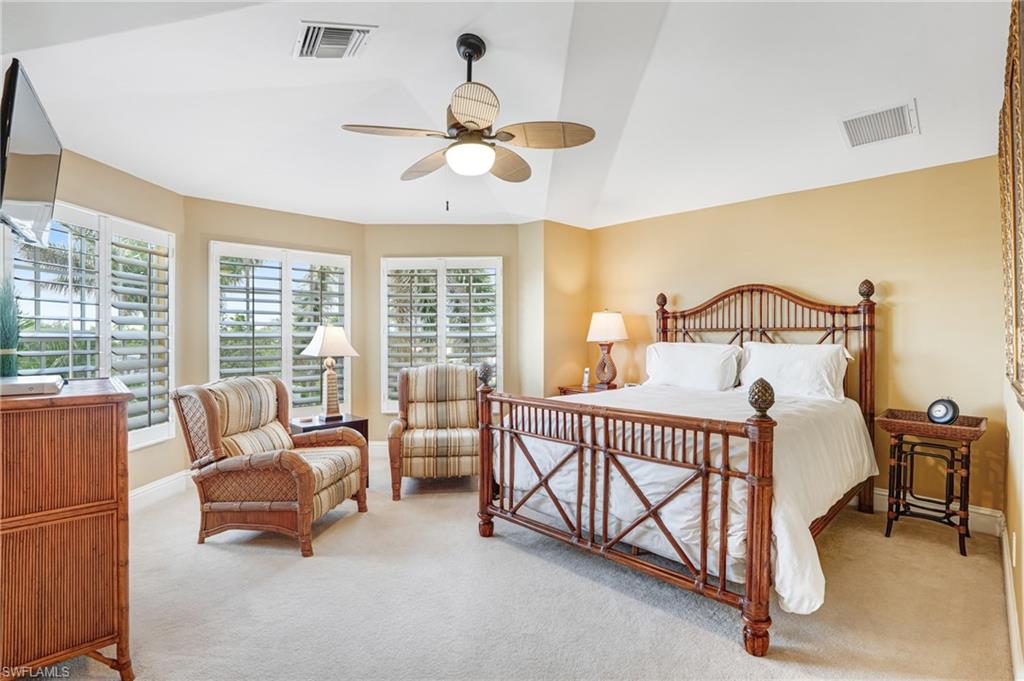Bedroom featuring light carpet, a ceiling fan, and lofted ceiling - Virtually Edited Image